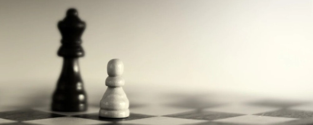 Photo of one black chess piece and one white chess piece on a board
