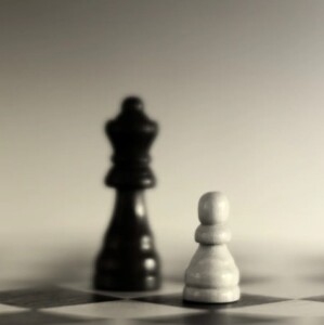 Photo of one black chess piece and one white chess piece on a board