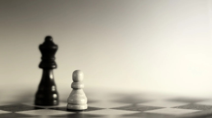 Photo of one black chess piece and one white chess piece on a board